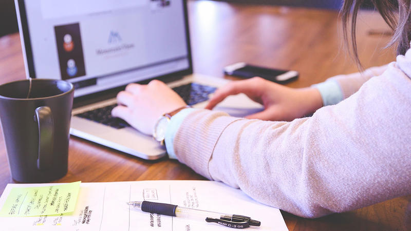 Employee typing on a laptop stock photo